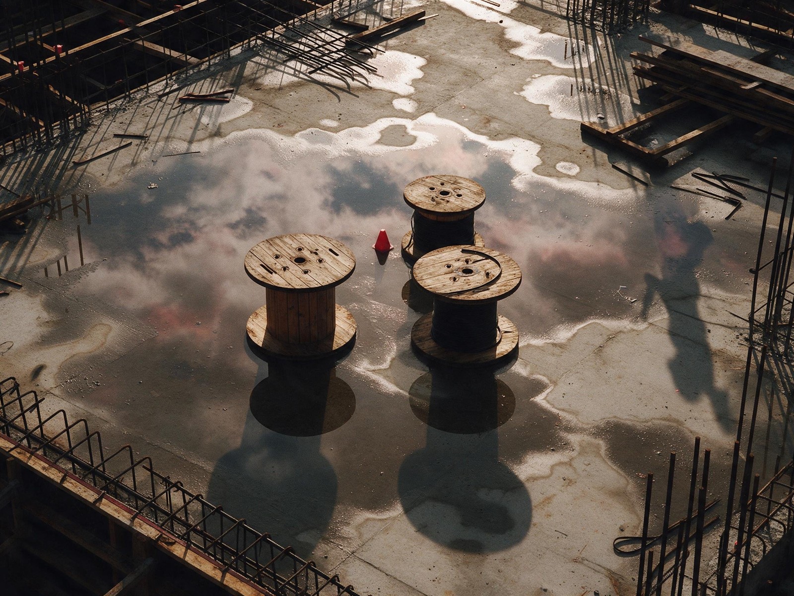 Three cable drums on a concrete slab in morning light